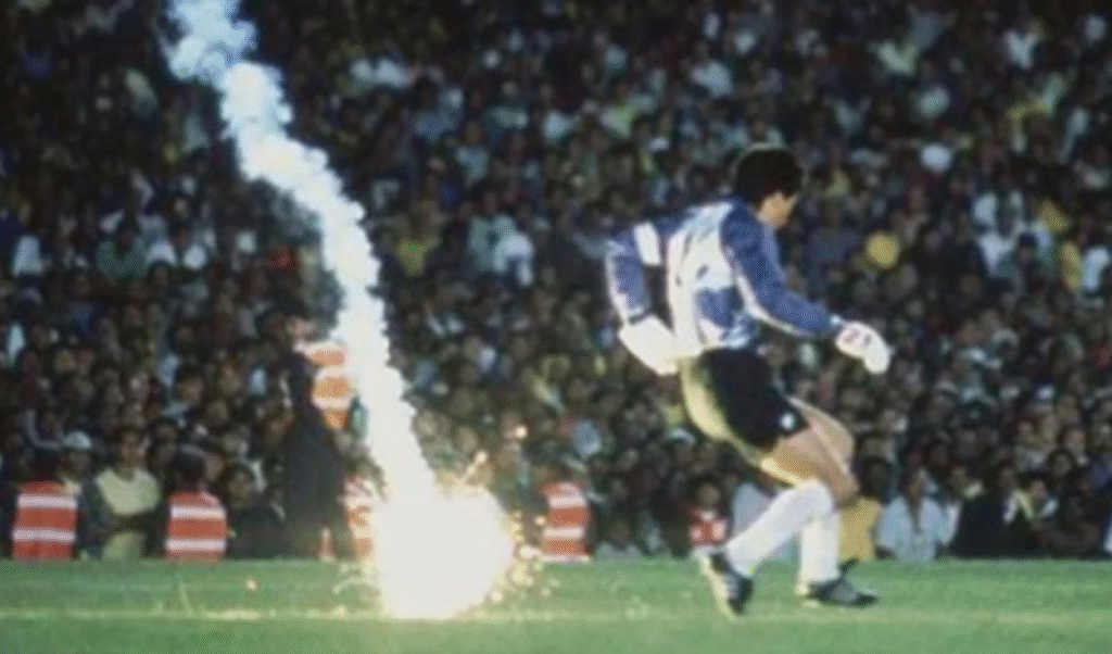 El arquero de la Selección Chilena, Roberto Rojas, se lanza al suelo tras la caída de una bengala durante el partido ante Brasil en el Maracaná por las Eliminatorias al Mundial 1990.