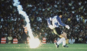 El arquero de la Selección Chilena, Roberto Rojas, se lanza al suelo tras la caída de una bengala durante el partido ante Brasil en el Maracaná por las Eliminatorias al Mundial 1990.