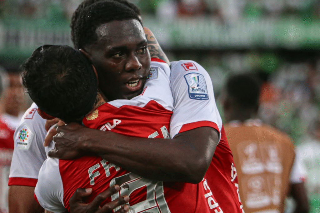 Omar Fernández Frasica celebra con un compañero tras marcar en la victoria de Independiente Santa Fe sobre Atlético Nacional, en el clásico reciente de la Liga BetPlay.