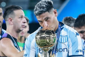 Maximiliano Salas besa un trofeo dorado con la camiseta de Racing, en un festejo tras la consagración del equipo