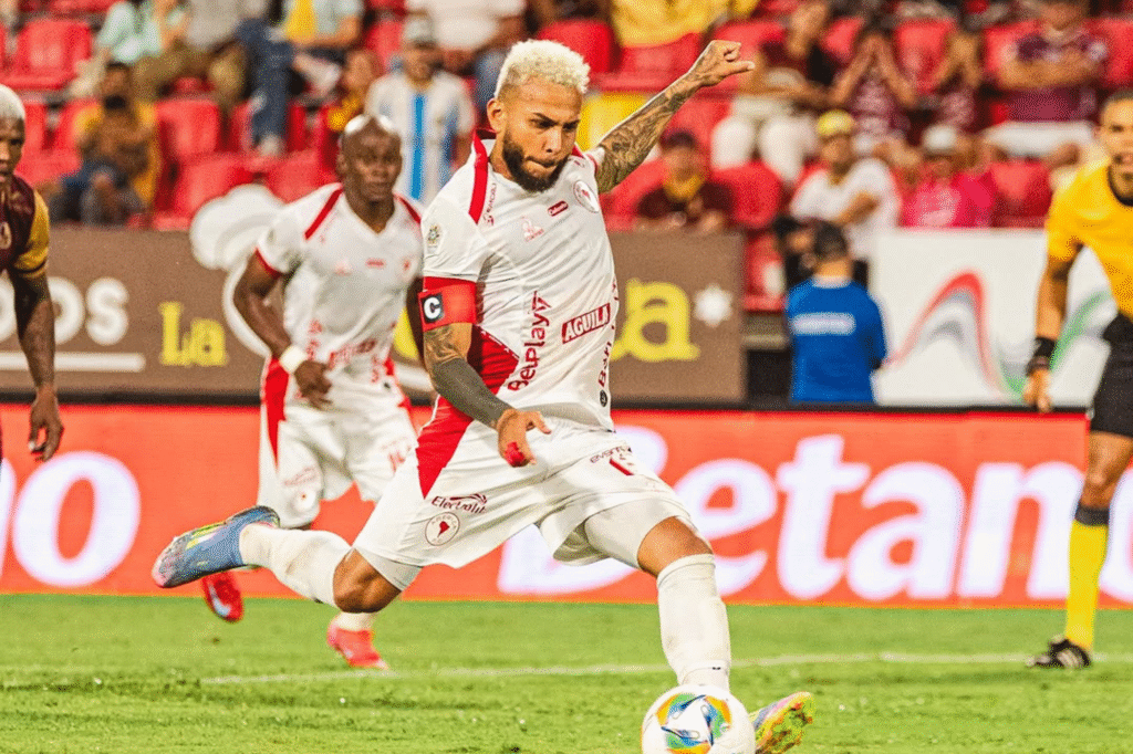 Duvan Vergara de América de Cali convierte un penal durante un partido frente a Deportes Tolima, en un estadio repleto de público.